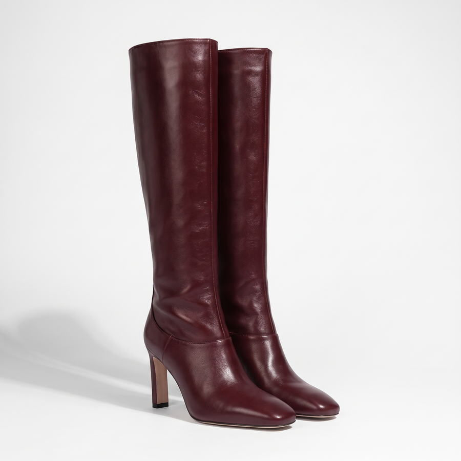 VogueStiletto elegant knee-high bordeaux leather boots with pointed toe and stiletto heel, studio product photo