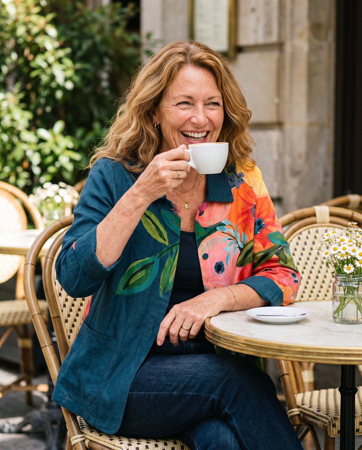 Persephone floral print blouse worn by a model at a sunlit cafe
